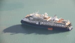 Ocean Explorer during its grounding last year. The incident demonstrated the dangers of allowing cruise ships to visit highly remote fjords and may ultimately lead to changes in the law. Photo: Air Force / Joint Arctic Command