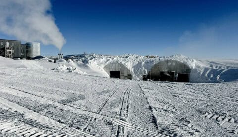 View of the snow overburden on the exterior of the arches containing the Admunsen-Scott Station’s power plant (exhaust pipes on left), logistics warehouse (left doorway), and vehicle maintenance facility (right doorway). Extensions to the air vents for the arches can be seen above the vehicle maintenance facility, indicating the depth of the snow. Photo: Seth Pilgrim