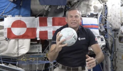 The ESA astronaut Andreas Mogensen with a handball on the International Space Station in August. In the background are the three flags from the Danish Realm that he represents, including the
